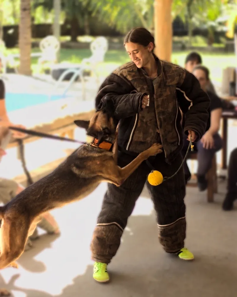 Mulher confiante caminhando com seu cão de proteção em ambiente urbano